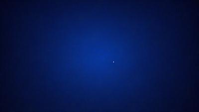 The primary subject of the image is a single star, which is the main object in the scene. The setting is a dark blue sky, with no other objects or backdrop visible. The visual style of the image is a photo, capturing the star in its natural environment. The colors and mood of the image are predominantly dark and moody, with the star being the only bright and prominent feature in the sky.