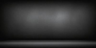 The primary subject of the image is a black wall. The setting is a dark room, and the visual style is a black and white photo. The colors and mood of the image are predominantly dark and moody, with a sense of mystery and depth.