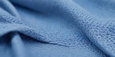 The primary subject of the image is a blue piece of fabric, possibly a sheet or a blanket. The setting is a room with a blue background, which creates a cohesive and visually appealing environment. The visual style is a close-up of the fabric, showcasing its texture and details. The colors and mood of the image are predominantly blue, giving it a calm and soothing atmosphere.
