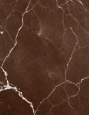 The image features a brown marble wall with a pattern of white and brown veins. The wall appears to be made of stone, giving it a natural and textured appearance. The primary subject of the image is the marble wall, which serves as the main focus of the scene. The setting is indoors, likely in a room with a stone or marble theme. The visual style of the image is a close-up of the marble wall, showcasing its unique texture and pattern. The colors and mood of the