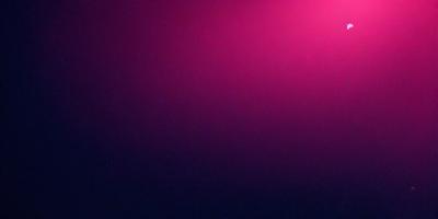 The primary subject of the image is a purple wall. The setting is a dark room, and the visual style appears to be a photo. The dominant colors are purple and dark, creating a moody atmosphere.