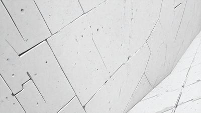 The primary subject of the image is a white wall with a lot of cracks and chips. The setting is a room with a white brick wall, and the visual style is a close-up of the wall. The colors and mood of the image are predominantly white, giving it a clean and minimalist appearance.