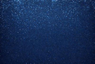 The primary subject of the image is a blue sky with a few stars visible. The setting is a dark blue background, which contrasts with the bright stars. The visual style is a photo, capturing the beauty of the night sky. The colors and mood of the image are serene and peaceful, as the stars twinkle against the dark background.