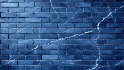 The primary subject of the image is a blue brick wall with a pattern of white lines on it. The setting is a brick wall, and the visual style is a photo. The dominant colors are blue and white, creating a calm and serene atmosphere.