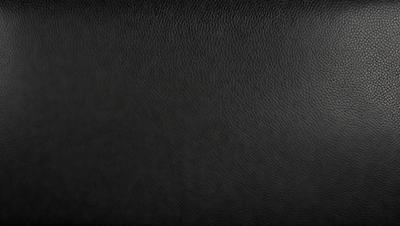 The primary subject of the image is a black leather surface. The setting is a black background, and the visual style is a close-up of the leather surface. The colors and mood of the image are predominantly dark and moody, with the black leather creating a sense of depth and contrast.