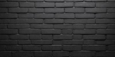 The primary subject of the image is a black brick wall. The setting is a dark room, and the visual style is a close-up of the brick wall. The dominant colors are black and grey, creating a moody atmosphere.