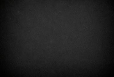 The primary subject of the image is a black background. The setting is a dark, empty space with no visible objects or elements. The visual style is a black and white photo, which gives the image a classic and timeless appearance. The colors and mood are predominantly dark and moody, creating a sense of mystery and depth.