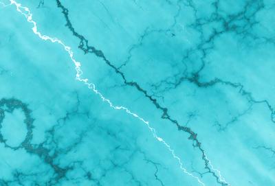 The primary subject of the image is a blue marble wall with a crack in it. The setting is a room with a blue marble wall, and the visual style is a photo. The dominant colors are blue and white, creating a calm and serene atmosphere.