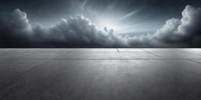 The primary subject of the image is a large, empty concrete surface. The setting is an outdoor area with a cloudy sky above. The visual style is a black and white photo, giving the image a classic and timeless appearance. The colors and mood are predominantly dark and moody, with the cloudy sky and the empty concrete surface creating a sense of emptiness and solitude.