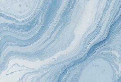 The primary subject of the image is a blue and white marbled surface, which appears to be a marble tile or a marble-like material. The setting is a room with a blue and white color scheme, which complements the marbled surface. The visual style of the image is a close-up of the marbled surface, showcasing its intricate patterns and textures. The colors and mood of the image are predominantly blue and white, creating a calm and elegant atmosphere.