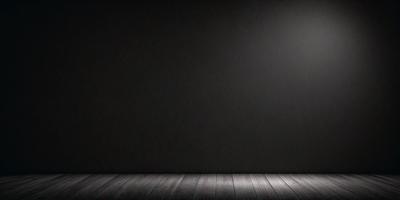 The primary subject of the image is a black wall with a wooden floor. The setting is a room with a black background, which creates a dramatic and moody atmosphere. The visual style is a photo, capturing the contrast between the black wall and the wooden floor. The colors and mood of the image are predominantly dark, with the black wall and wooden floor being the main focus.