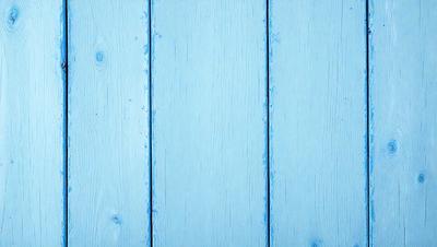 The primary subject of the image is a blue wooden wall. The setting is a room with a blue wooden wall, and the visual style is a photo. The dominant colors are blue and white, creating a calm and serene atmosphere.