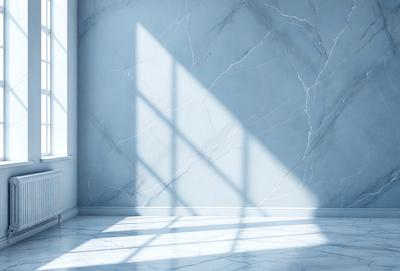 The primary subject of the image is a marble wall with a window. The setting is a room with a blue wall and a white floor. The visual style is a photo, and the colors and mood are predominantly white and blue, creating a calm and serene atmosphere.