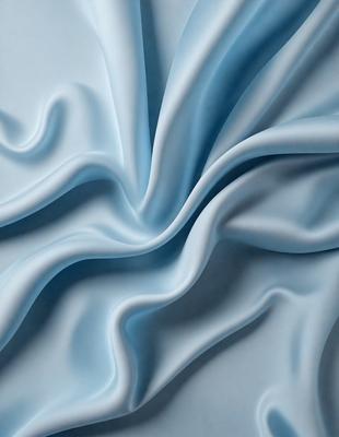 The primary subject of the image is a blue fabric, which appears to be a piece of cloth or a sheet. The setting is a white background, which provides a clean and uncluttered environment for the fabric. The visual style of the image is a close-up of the fabric, showcasing its texture and details. The colors and mood of the image are predominantly blue, creating a calm and soothing atmosphere.