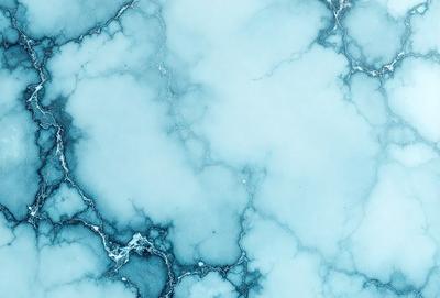 The primary subject of the image is a blue and white marbled surface, which appears to be a wall or a piece of art. The setting is a room with a blue and white marbled wall, and the visual style is a close-up of the marbled surface. The colors and mood of the image are predominantly blue and white, creating a calm and serene atmosphere.