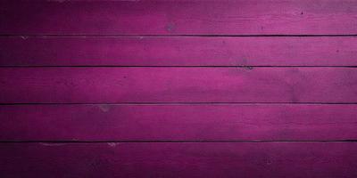 The primary subject of the image is a purple wooden wall. The setting is a room with a purple wall, and the visual style is a close-up of the wall. The dominant colors are purple and pink, creating a warm and inviting atmosphere.