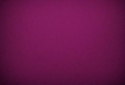 The primary subject of the image is a purple background. The setting is a dark purple surface, which creates a moody atmosphere. The visual style is a close-up of the purple background, emphasizing its color and texture. The colors and mood of the image are predominantly purple, giving it a dramatic and intense appearance.