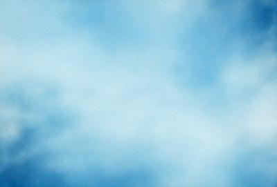 The primary subject of the image is a cloudy blue sky. The setting is a vast, open space with no visible landmarks or objects. The visual style is a natural, outdoor scene with a focus on the sky. The colors and mood are predominantly blue and serene, creating a peaceful and tranquil atmosphere.