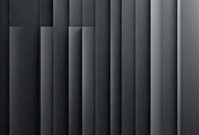 The primary subject of the image is a black and white patterned wall. The setting is a dark room, and the visual style is a black and white photo. The dominant colors are black and white, creating a moody atmosphere.