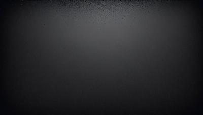 The primary subject of the image is a black background with a few white specks. The setting is a dark room, and the visual style is a black and white photo. The dominant colors are black and white, creating a moody atmosphere.