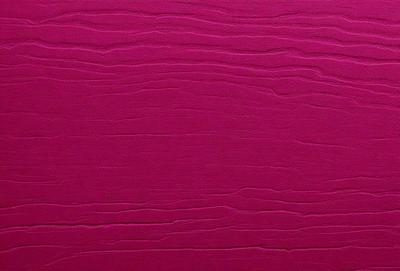The primary subject of the image is a pink wall with a patterned texture. The setting is a room with a pink wall, and the visual style is a close-up of the wall. The dominant colors are pink and red, creating a warm and inviting atmosphere.