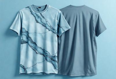The primary subject of the image is a blue shirt with a marbled design. The shirt is displayed on a blue background, giving it a clean and modern appearance. The visual style of the image is a close-up of the shirt, showcasing its intricate design and texture. The colors and mood of the image are predominantly blue, creating a calm and soothing atmosphere.