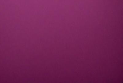 The primary subject of the image is a large, purple wall. The setting is a room with a pink background. The visual style is a close-up of the purple wall, which gives a sense of depth and texture. The dominant colors are purple and pink, creating a warm and inviting atmosphere.