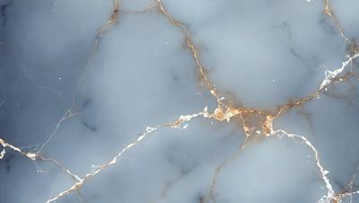 The primary subject of the image is a marble countertop with a gold-colored vein running through it. The setting is a kitchen, and the visual style is a close-up of the marble countertop. The colors and mood of the image are predominantly neutral, with the gold vein adding a touch of warmth and sophistication to the overall atmosphere.