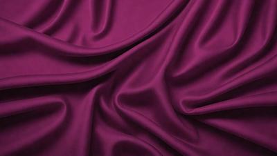 The primary subject of the image is a purple fabric, which is the main object, scene, or focus of the image. The setting or background is a purple curtain, and the visual style is a close-up of the fabric. The colors and mood of the image are predominantly purple, creating a calm and serene atmosphere.