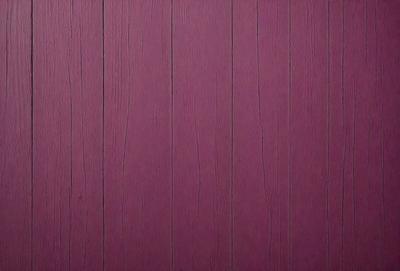 The primary subject of the image is a purple wall with a wooden texture. The setting is a room with a wooden wall, and the visual style is a close-up of the wall. The dominant colors are purple and brown, creating a warm and inviting atmosphere.
