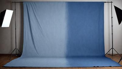 The primary subject of the image is a blue and white blanket, which is draped over a wooden floor. The setting is indoors, with the blanket covering the floor, creating a cozy and inviting atmosphere. The visual style of the image is a close-up of the blanket, showcasing its texture and colors. The dominant colors in the image are blue and white, with the blue blanket being the main focus of the scene.
