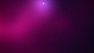 The primary subject of the image is a purple background with a pink hue. The setting appears to be a dark, foggy environment. The visual style of the image is a combination of a photo and digital art, creating a unique and intriguing atmosphere. The dominant colors in the image are purple and pink, which contribute to a moody and mysterious mood.