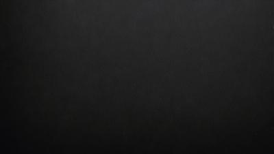 The primary subject of the image is a black background. The setting is a dark room, and the visual style is a black and white photo. The colors and mood of the image are dark and moody, creating a sense of mystery or drama.