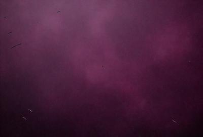 The primary subject of the image is a purple sky with clouds. The setting is a cloudy sky, and the visual style is a photo. The dominant colors are purple and pink, creating a moody and atmospheric mood.
