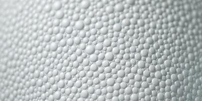 The primary subject of the image is a close-up of a white surface with a pattern of small white bubbles. The setting appears to be a white background, and the visual style is a close-up of the bubbles. The colors and mood of the image are predominantly white, giving it a clean and simple appearance.