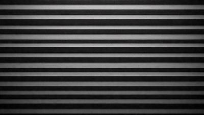 The primary subject of the image is a black and white striped pattern. The setting is a wall, and the visual style is a photo. The dominant colors are black and white, creating a classic and timeless atmosphere.