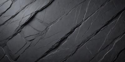 The primary subject of the image is a close-up of a black, textured surface, possibly a piece of leather or a stone wall. The setting appears to be a dark room, with the surface being the main focus of the image. The visual style is a close-up, which emphasizes the details of the surface. The colors and mood of the image are predominantly dark, with the black surface being the most prominent element.