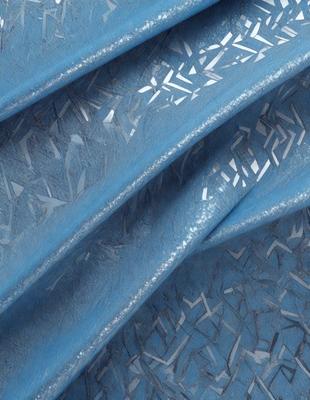 The primary subject of the image is a blue fabric with a pattern of silver designs. The setting is a staircase, and the visual style appears to be a combination of a photo and digital art. The colors are predominantly blue and silver, creating a calm and elegant atmosphere.