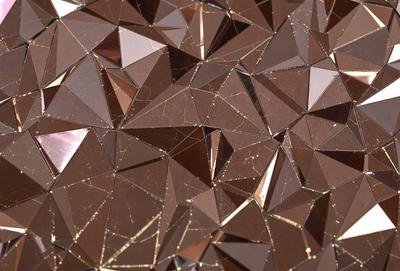 The primary subject of the image is a close-up of a patterned surface, which appears to be a combination of gold and brown colors. The setting is a room with a mirrored surface, reflecting the patterned surface. The visual style is a mix of digital art and illustration, creating a unique and intricate design. The colors and mood of the image are warm and inviting, with the gold and brown tones evoking a sense of luxury and sophistication.