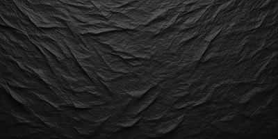 The primary subject of the image is a black cloth with a pattern of wrinkles and folds. The setting is a dark background, which contrasts with the black cloth. The visual style is a close-up of the cloth, showcasing its texture and pattern. The colors and mood of the image are predominantly dark, with the black cloth being the main focus.