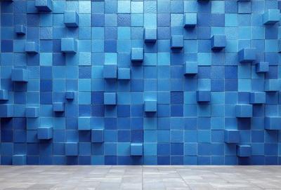 The primary subject of the image is a blue wall with a pattern of blue squares. The setting is a room with a blue wall, and the visual style is a photo. The dominant colors are blue, and the overall atmosphere is calm and serene.