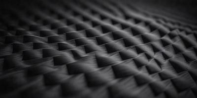 The primary subject of the image is a black and white patterned surface, which appears to be a piece of fabric or a mattress cover. The setting is a dark room, and the visual style is a close-up of the patterned surface. The colors and mood of the image are predominantly black and white, giving it a classic and timeless appearance.