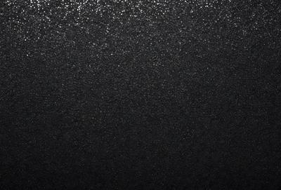 The primary subject of the image is a black background with a pattern of glittering specks. The setting is a dark room, and the visual style appears to be a combination of a photo and a digital art or illustration. The colors and mood of the image are predominantly dark and moody, with the glittering specks adding a touch of intrigue and interest to the overall atmosphere.