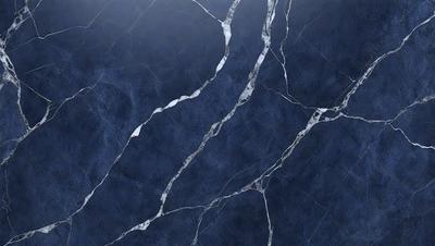 The primary subject of the image is a blue marble wall with a cracked pattern. The setting is a room with a blue background. The visual style is a close-up of the marble wall, showcasing its unique texture and design. The colors and mood of the image are predominantly blue, creating a calm and serene atmosphere.