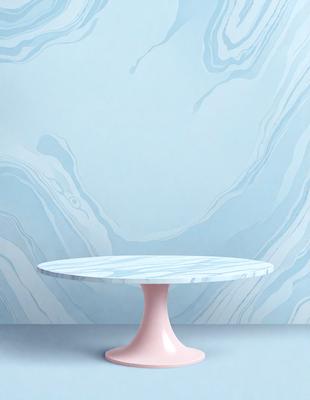 The primary subject of the image is a pink and white table, which is placed on a blue marble floor. The table is positioned in front of a blue wall, creating a visually appealing contrast between the table and the wall. The setting appears to be a modern and stylish interior design, with the table serving as a focal point in the space. The visual style of the image is a combination of photo and digital art, resulting in a high-quality and detailed representation of the scene. The colors and mood of
