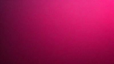The primary subject of the image is a large, pink wall. The setting is a room with a red background, which creates a bold and vibrant atmosphere. The visual style is a close-up of the wall, showcasing its color and texture. The dominant colors are red and pink, which evoke a sense of warmth and energy.