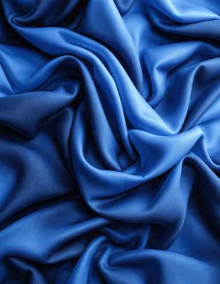 The primary subject of the image is a blue fabric, which is the main object, scene, or focus of the image. The setting or background is a blue cloth, and the visual style is a photo. The dominant colors and overall atmosphere are blue and serene.