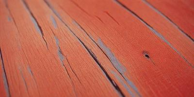 The primary subject of the image is a wooden surface, possibly a table or a piece of wood. The setting is a room with a wooden floor, and the visual style is a close-up of the wooden surface. The colors and mood of the image are predominantly orange, giving it a warm and natural atmosphere.