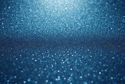 The primary subject of the image is a blue background with a pattern of glittering, shiny, and sparkling blue dots. The setting appears to be a dark room, and the visual style is a close-up of the blue background. The colors and mood of the image are predominantly blue, creating a serene and calming atmosphere.
