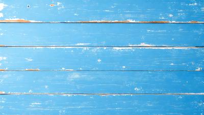 The primary subject of the image is a blue wooden wall. The setting is a room with a blue wooden wall, and the visual style is a photo. The dominant colors are blue and white, creating a calm and serene atmosphere.